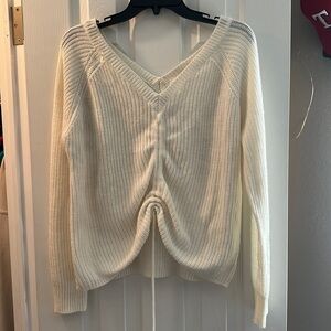 White crocheted sweater with a low back and draw string to cinch the front